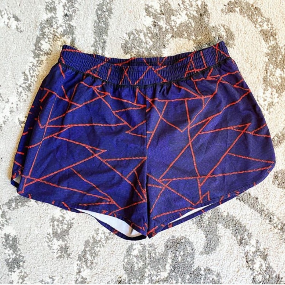 Dark purple athletic shorts with an orange pattern